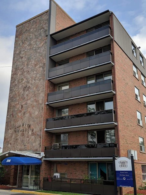 A tall brick building with balconies and awnings.