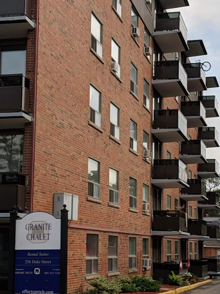 A brick building with balconies and a sign that says Granite Chalet.