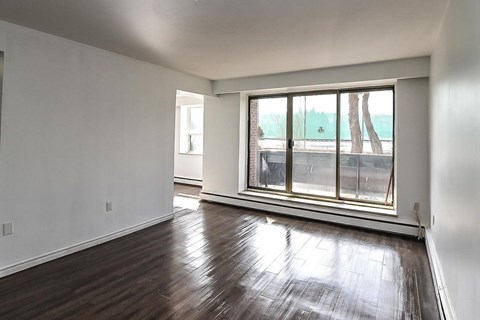 A room with a large window and wooden flooring.