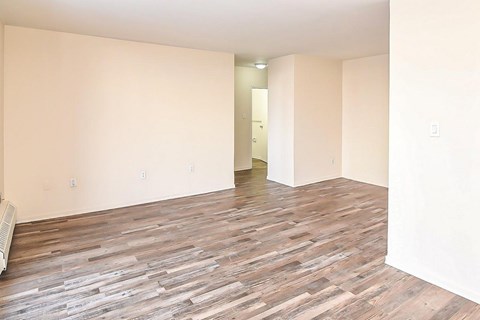 A room with wooden flooring and white walls.