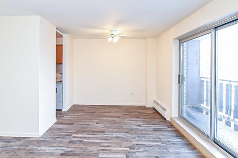 A room with a wooden floor and a window overlooking a snowy street.