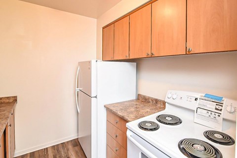 A kitchen with a white stove and a white refrigerator.