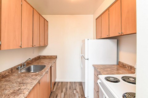 A kitchen with wooden cabinets and a white refrigerator.