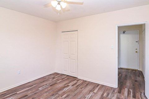 A room with a ceiling fan and two doors.