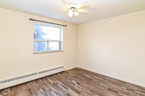 A room with a window and a ceiling fan.