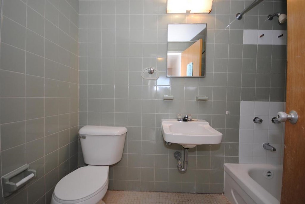 A bathroom with a toilet, sink, and bathtub.