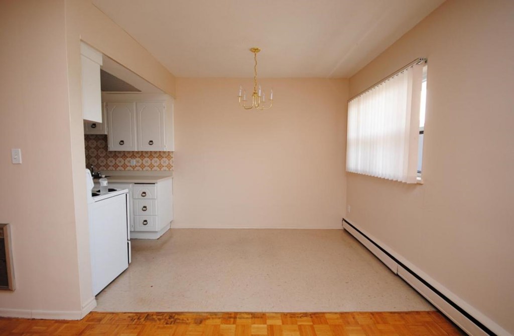 A kitchen with a white refrigerator and a chandelier hanging from the ceiling.