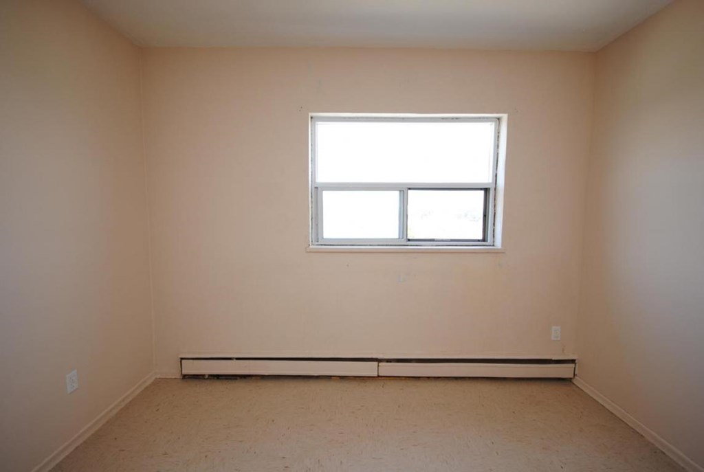 A room with a window and a bench.