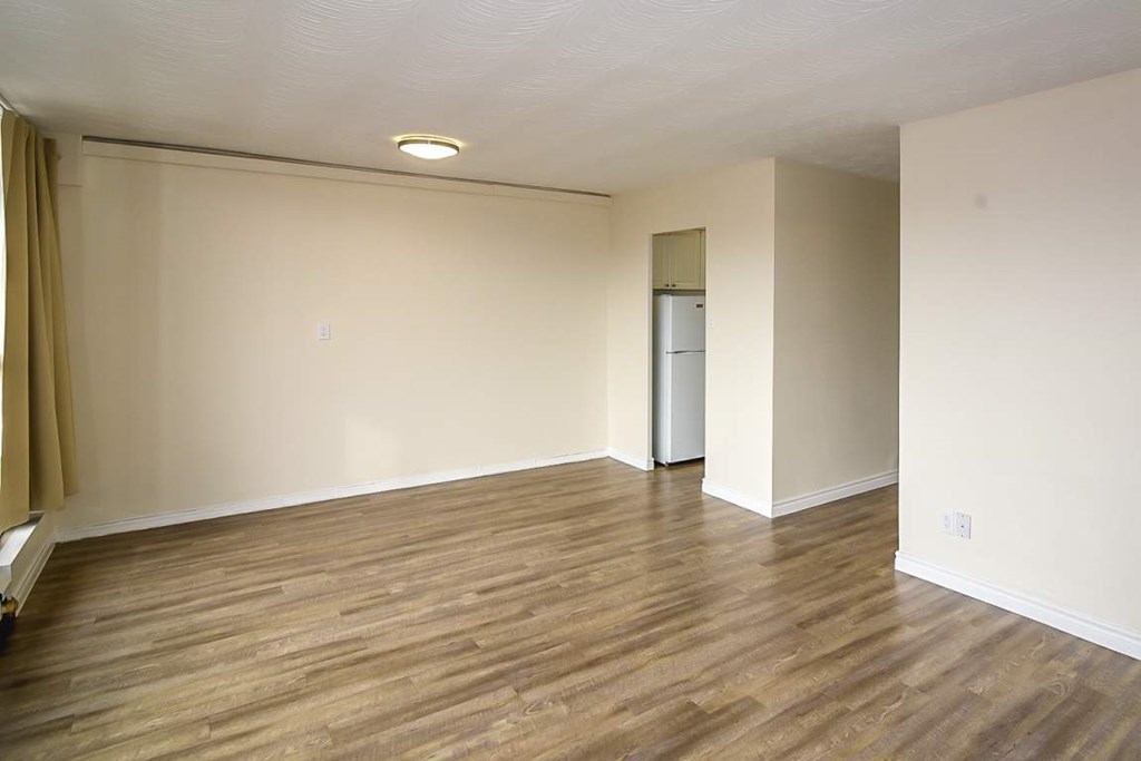 A room with wooden flooring and a white door.