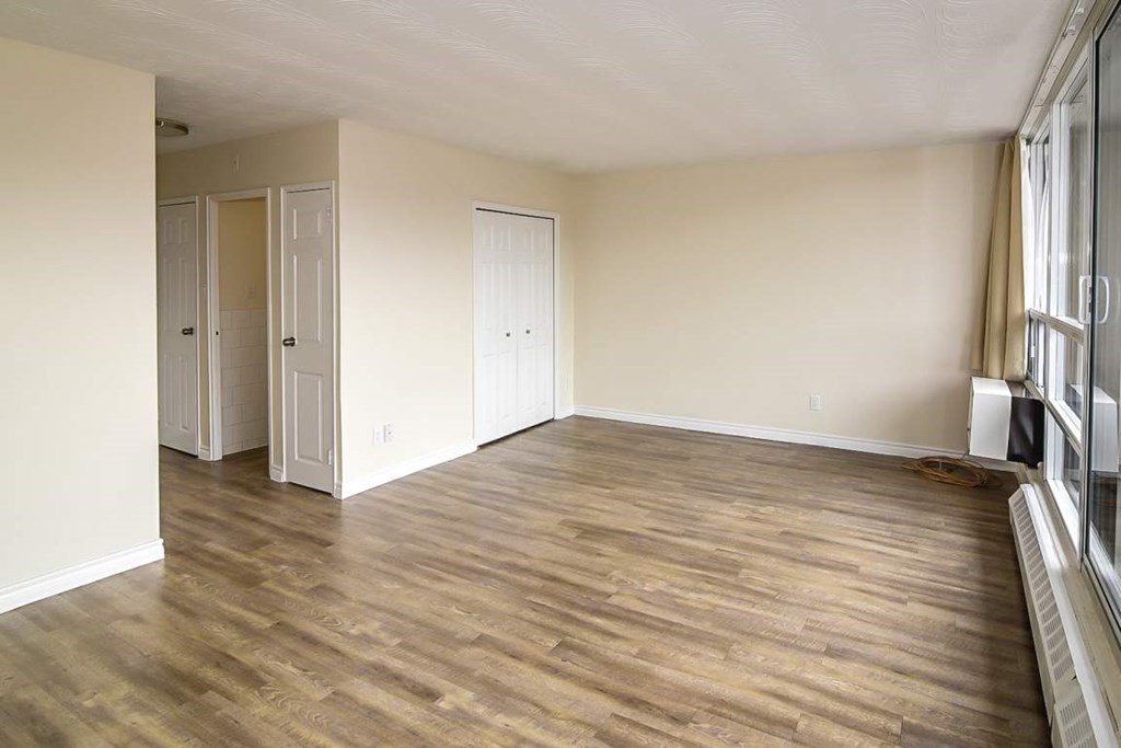 A room with wooden flooring and white walls.