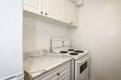 A white kitchen with a stove and oven.