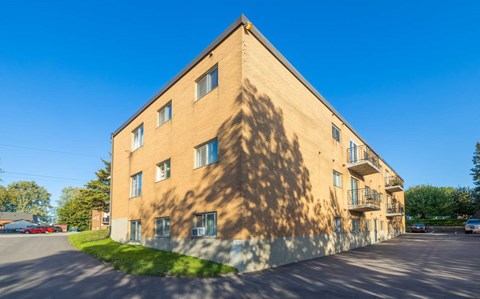 A large building with a flat roof and a parking lot in front.