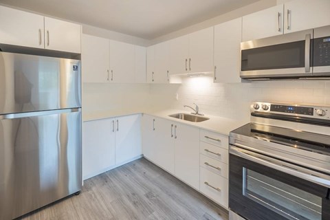 A modern kitchen with stainless steel appliances and white cabinets.