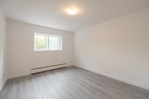 A room with a window and a radiator on the wall.