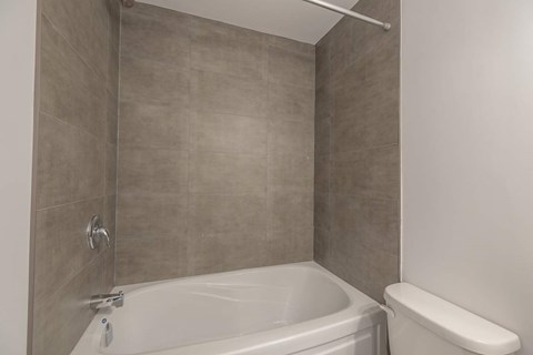 A bathroom with a tub and toilet.