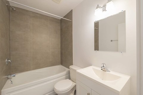 A white bathroom with a toilet, sink, and bathtub.