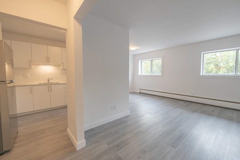 A room with a window and a wooden floor.