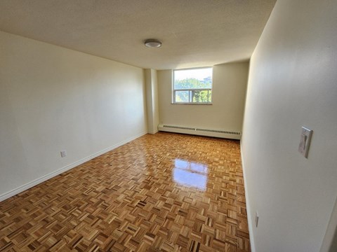 A room with a wooden floor and a window.