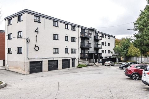 Apartment building number 416 with cars parked in front.