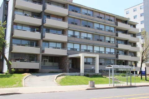 A large concrete building with many windows and balconies.