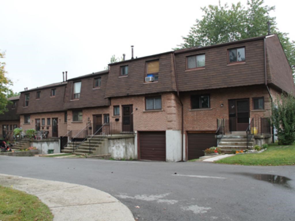 A brown building with a grey road in front.