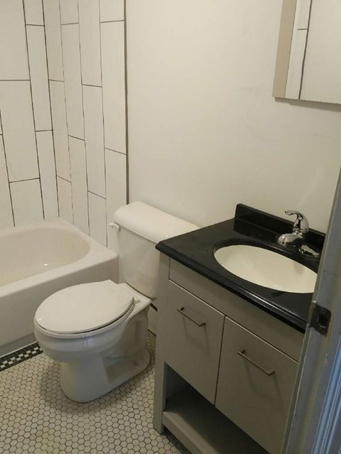 A white toilet sits next to a sink in a bathroom.