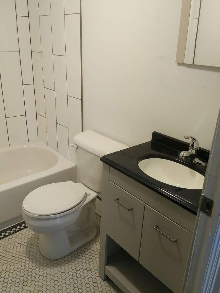 A white toilet sits next to a sink in a bathroom.