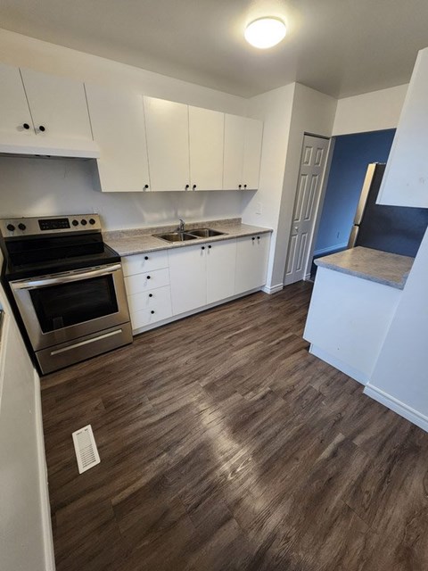 A kitchen with white cabinets and a black stove top oven.