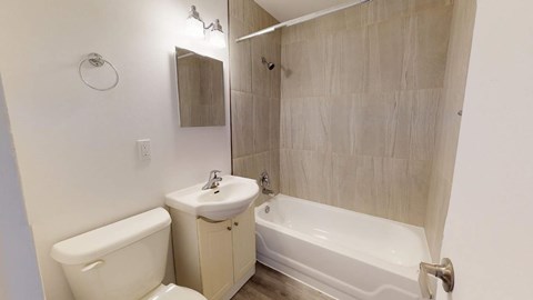A white toilet sits next to a sink in a small bathroom.