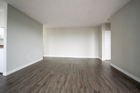 A room with wooden flooring and white walls.