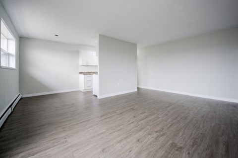 A room with wooden flooring and white walls.