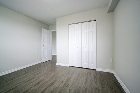 A room with a white door and a white closet door.