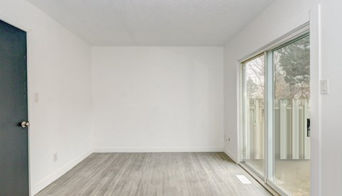 A room with a grey door and a white wall.