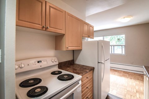 A kitchen with a white stove and wooden cabinets.