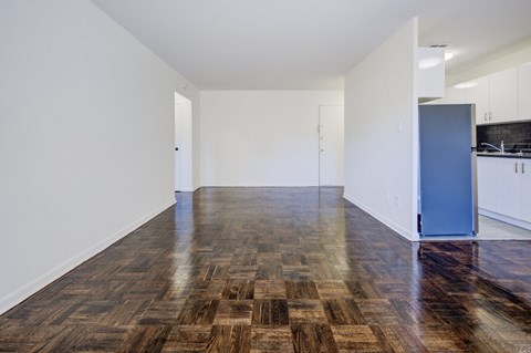 A room with a wooden floor and a blue door.
