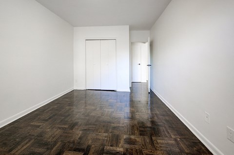 A room with a wooden floor and two white doors.