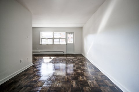 A room with a wooden floor and a window.