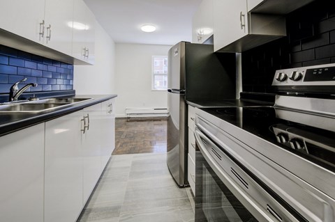 A modern kitchen with black and white appliances and cabinets.