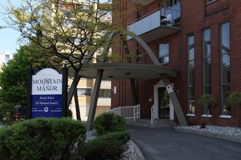 A sign for Mountain Manor is in front of a building.