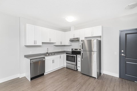 A kitchen with white cabinets and stainless steel appliances.