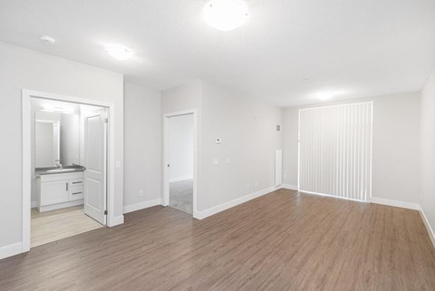 A room with wooden flooring and white walls.