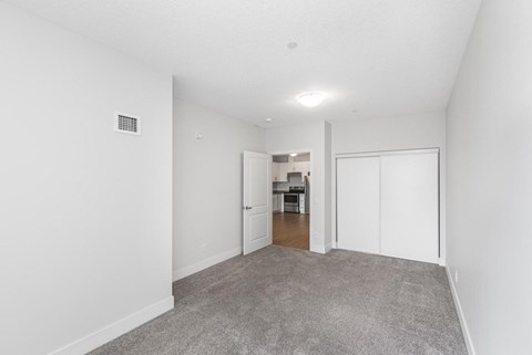 A room with a carpeted floor and a white door.
