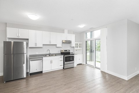 A modern kitchen with stainless steel appliances and white cabinets.