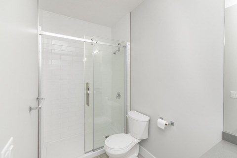 A white toilet in a bathroom with a glass shower door.