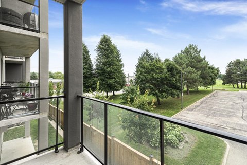 A balcony overlooks a green yard.