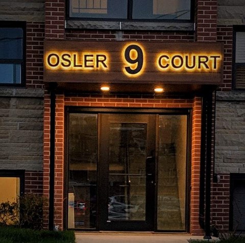 The front of a building with a glass door and a sign that says Osler 9 Court.
