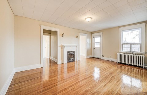 A room with a fireplace and wood flooring.
