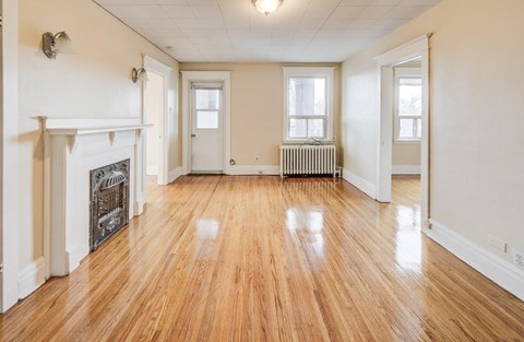 A room with wooden floors and a fireplace.