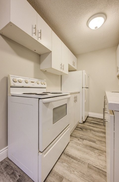 A white stove and oven in a kitchen with wooden flooring.