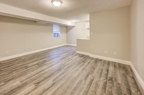 A room with wooden flooring and a window.